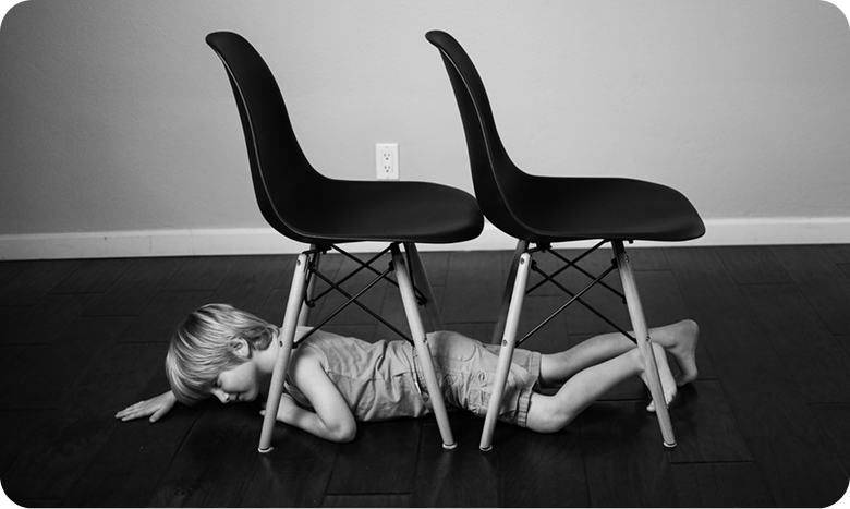 kid under chairs